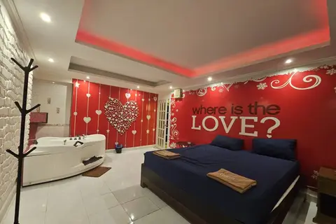 Katherine Massage: room with a bed, jacuzzi and "Where is the love?" wall