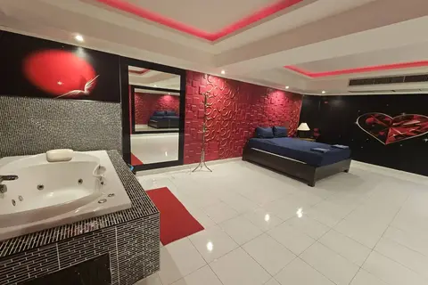 Katherine Massage: room with a jacuzzi, bed and red feature wall