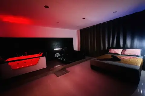 Nuru Spa: red-lit room with a glowing jacuzzi and bed
