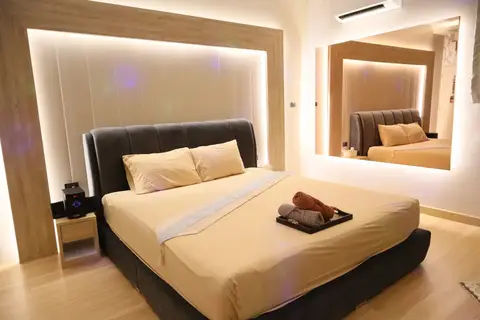 Pink X Station: room with a bed and backlit headboard